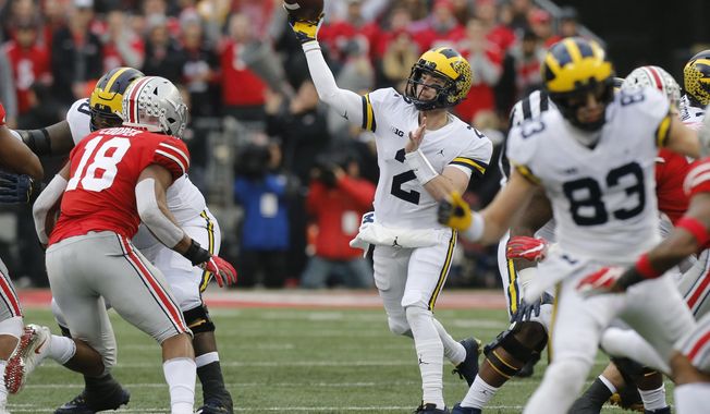 FILE - In this Nov. 24, 2018, file photo, Michigan quarterback Shea Patterson throws a pass against Ohio State during an NCAA college football game in Columbus, Ohio. Magistrate Judge Norah McCann King moved a change of plea hearing from June 18 to July 1, 2020, for Daniel Rippy. Rippy is accused of making an &amp;quot;electronic communication&amp;quot; threat from California during this game between Ohio State and the University of Michigan threatening a shooting and vowing to hurt players on the football team. (AP Photo/Jay LaPrete)