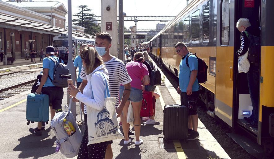 Passengers disembark from a train that arrived from the Czech Republic in Rijeka, Croatia, Wednesday, July 1, 2020. A train carrying some 500 tourists from the Czech Republic has arrived to Croatia as the country seeks to attract visitors after easing lockdown measures against the new coronavirus. (AP Photo)