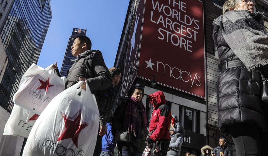 FILE - In this Nov. 29, 2019, file photo a shopper leaves Macy&#39;s department store with bags in both hands during Black Friday shopping in New York. Macy’s is refashioning what the Black Friday sales bonanza will look like in a pandemic. The company&#39;s CEO Jeff Gennette told analysts Wednesday, July 1, 2020, said that the department store chain will be pivoting its Black Friday business more toward online and will likely be going “full force” with marketing right after Halloween.  (AP Photo/Bebeto Matthews, File)
