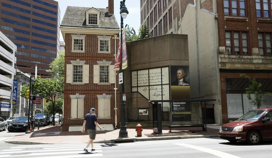 In this June 30, 2020, photo, a man walks in front of the Declaration House in Philadelphia. Countless words have been written about the Declaration of Independence and Thomas Jefferson, but few about Robert Hemings, the slave who was on hand as Jefferson famously declared that “All men are created equal.”  According to the National Park Service, Hemings is not included in the exhibit texts of the Declaration House, a reconstruction of the home Jefferson stayed in as a guest of the Philadelphia bricklayer Jacob Graff. (AP Photo/Matt Slocum)