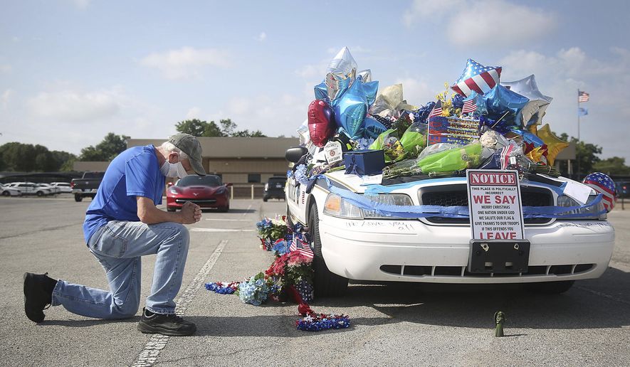 Dan Osborne prays at a makeshift memorial for Tulsa Police Officers Craig Johnson and Aurash Zarkeshan at Mingo Valley Division Tuesday, June 30, 2020. The officers were shot early Monday morning during a traffic stop. (Mike Simons/Tulsa World via AP)