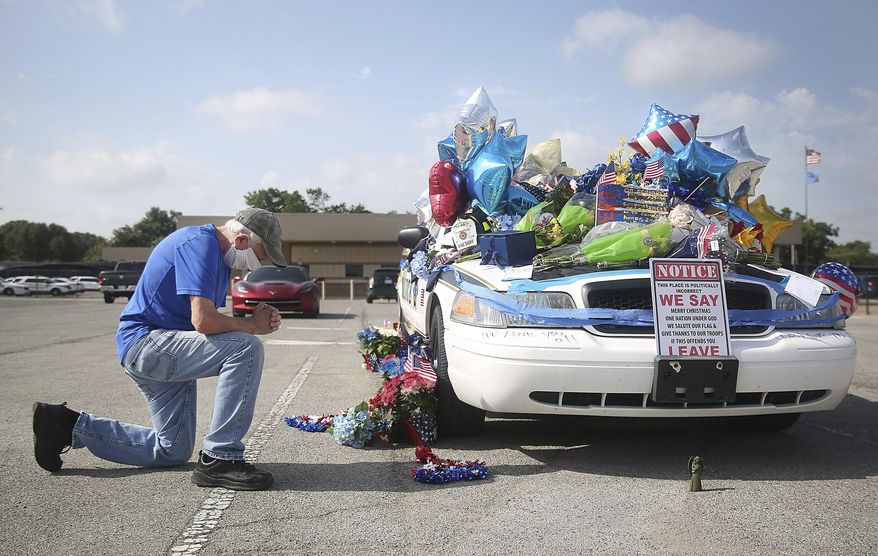 Dan Osborne prays at a makeshift memorial for Tulsa Police Officers Craig Johnson and Aurash Zarkeshan at Mingo Valley Division Tuesday, June 30, 2020. The officers were shot early Monday morning during a traffic stop. (Mike Simons/Tulsa World via AP)