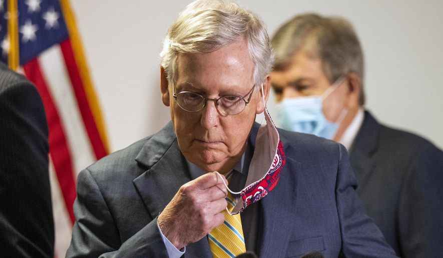 Senate Majority Leader Mitch McConnell, R-Ky., takes off his face mask as he walks toward the podium following a GOP policy meeting on Capitol Hill, Tuesday, June 30, 2020, in Washington. With McConnell is Sen. Roy Blunt, R-Mo. (AP Photo/Manuel Balce Ceneta)
