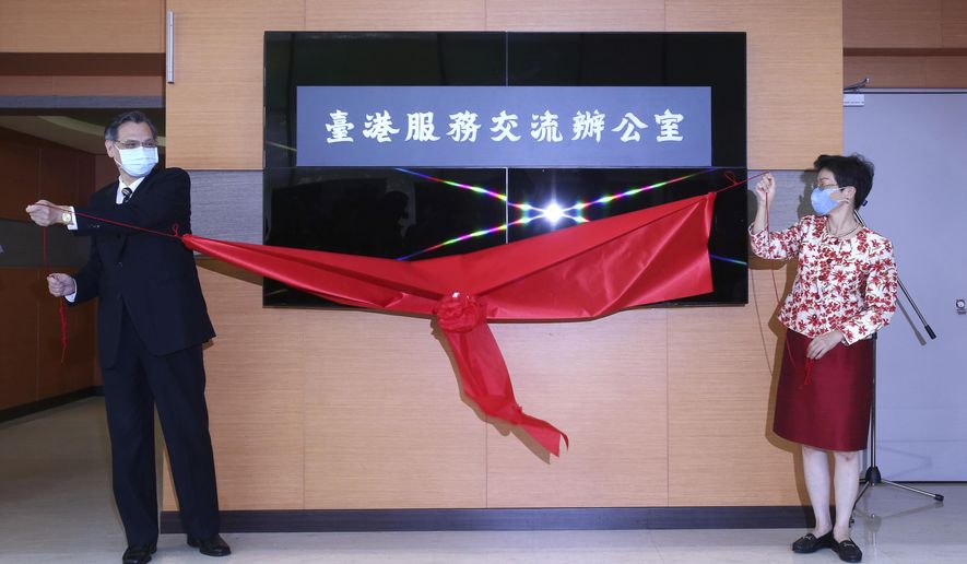 Katharine Chang, right, chairperson of Straits Exchange Foundation, and Chen Ming-tong, minister of the Mainland Affairs Council, unveil the plaque of the Taiwan Hong Kong Service Exchange Office during an opening ceremony in Taipei, Taiwan, Wednesday, July 1, 2020. Taiwan officially opened the specialized office to support Hong Kong people seeking to move to Taiwan after China’s passage of a national security law for Hong Kong. (AP Photo /Chiang Ying-ying)