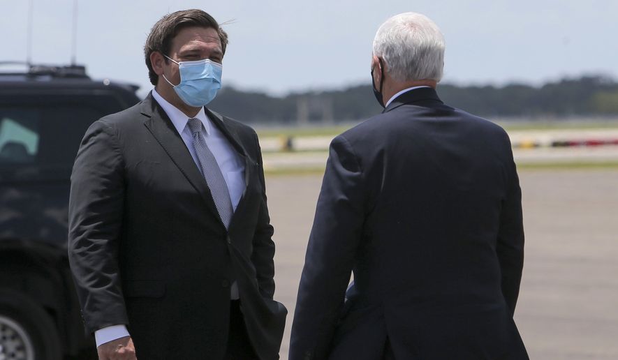 Florida Gov. Ron DeSantis greets Vice President Mike Pence upon his arrival at Tampa International Airport on Thursday, July 2, 2020, in Tampa. The Vice President met with Governor DeSantis regarding the efforts the state is making to combat COVID-19. (Ivy Ceballo/Tampa Bay Times via AP)