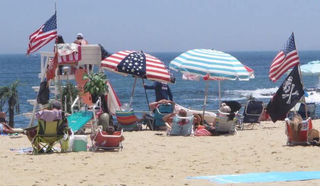 Flags line the beach in Belmar, N.J., on June 28, 2020. With large crowds expected at the Jersey Shore for the July Fourth weekend, some are worried that a failure to heed mask-wearing and social distancing protocols could accelerate the spread of the coronavirus. (AP Photo/Wayne Parry) **FILE**