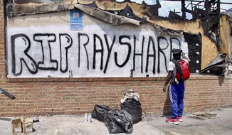 Joseth  Jett spray painted over the top of graffiti from the night before and paints RIP Rayshard Sunday, June 14, 2020, in Atlanta. On Saturday, protestors set fire to the Atlanta Wendy&#39;s where Rayshard Brooks, a 27-year-old black man, was shot and killed by Atlanta police Friday evening during a struggle in a Wendy&#39;s drive-thru line. (Steve Schaefer/Atlanta Journal-Constitution via AP)