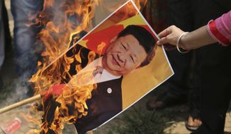 A Bharatiya Janata Party activist burns a photograph of Chinese President Xi Jinping during a protest in Jammu, India, Wednesday, July.1, 2020. Indian TikTok users awoke Tuesday to a notice from the popular short-video app saying their data would be transferred to an Irish subsidiary, a response to India&#39;s ban on dozens of Chinese apps amid a military standoff between the two countries. The quick workaround showed the ban was largely symbolic since the apps can’t be automatically erased from devices where they are already downloaded, and is a response to a border clash with China where 20 Indian soldiers died earlier this month, digital experts said. (AP Photo/Channi Anand)