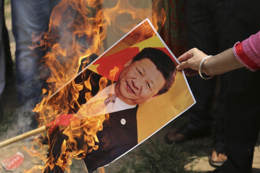 A Bharatiya Janata Party activist burns a photograph of Chinese President Xi Jinping during a protest in Jammu, India, Wednesday, July.1, 2020. Indian TikTok users awoke Tuesday to a notice from the popular short-video app saying their data would be transferred to an Irish subsidiary, a response to India&#x27;s ban on dozens of Chinese apps amid a military standoff between the two countries. The quick workaround showed the ban was largely symbolic since the apps can’t be automatically erased from devices where they are already downloaded, and is a response to a border clash with China where 20 Indian soldiers died earlier this month, digital experts said. (AP Photo/Channi Anand)