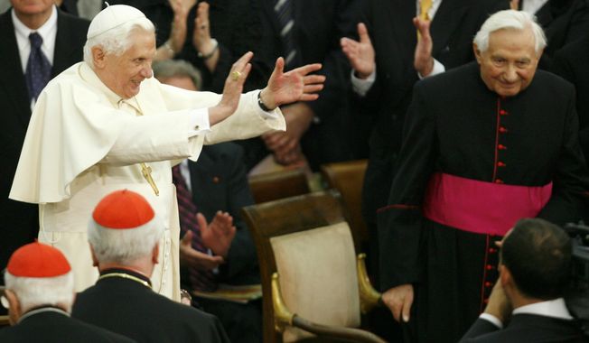 FILE - In this Saturday, Oct. 27, 2007 file photo, Pope Benedict XVI, center left, applauds, as his brother, Georg, right, looks on, during a concert by the German Symphonic Orchestra Bayerischer Rundfunk and the Bamberger Symphoniker, at the Paul VI Hall at the Vatican. The Rev. Georg Ratzinger, the older brother of Emeritus Pope Benedict XVI, who earned renown in his own right as a director of an acclaimed German boys’ choir, has died at age 96. The Regensburg diocese in Bavaria, where Ratzinger lived, said in a statement on his website that he died on Wednesday, July 1, 2020. (AP Photo/Andrew Medichini, File)