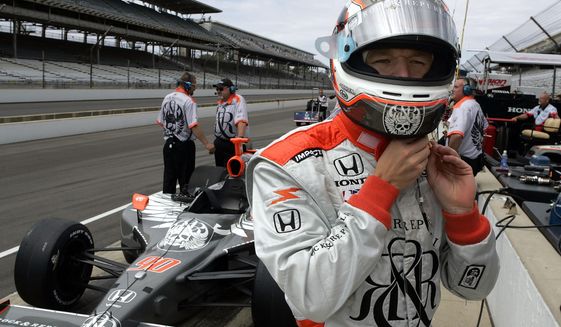 FILE - In this Friday, May 19, 2006 file photo, Indy Racing League driver Townsend Bell dons his helmet before practicing for the 90th running of the Indianapolis 500 at the Indianapolis Motor Speedway in Indianapolis.  NBC Sports analyst Townsend Bell will have his own unique double duty Saturday, July 4, 2020 when he calls the IndyCar race at Indianapolis Motor Speedway and then flies to Daytona International Speedway to compete in the IMSA sports car race.  (AP Photo/Tom Strattman, File)
