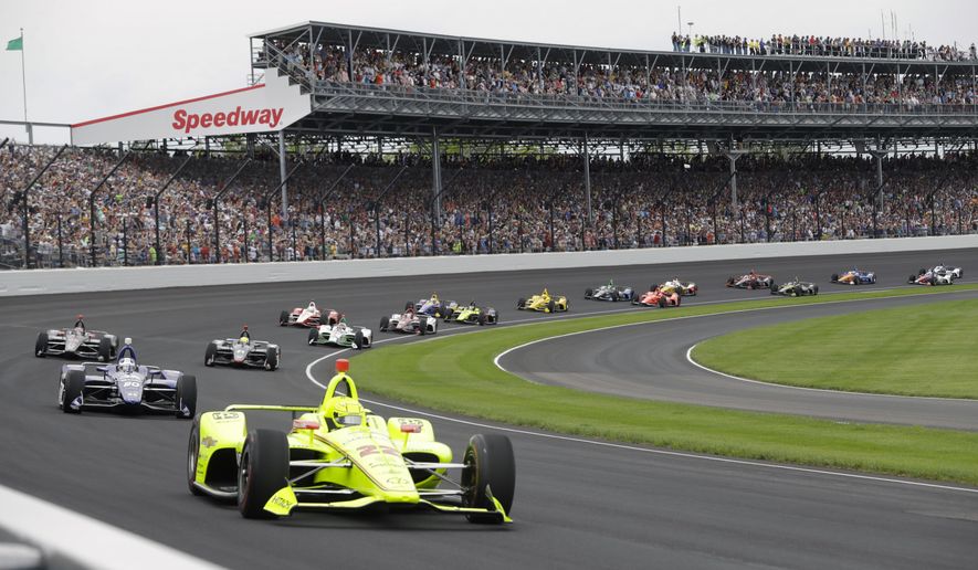 FILE - In this May 26, 2019, file photo, Simon Pagenaud, of France, leads the field through the first turn on the start of the Indianapolis 500 IndyCar auto race at Indianapolis Motor Speedway, in Indianapolis. The once frosty schism between the two biggest racing series in the United States has thawed and NASCAR&#39;s elite Cup Series will share a venue with IndyCar on the same weekend for the first time in history. (AP Photo/Darron Cummings, File)