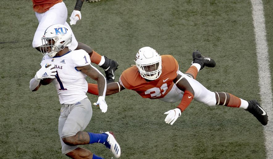 FILE - In this Oct. 19, 2019, file photo, Texas' DeMarvion Overshown (31) leaps to tackle Kansas running back Pooka Williams Jr. (1) during an NCAA college football game in Austin, Texas. Texas junior linebacker Overshown announced Thursday, July 2, 2020, he will sit out all team activities until the school starts making campus changes sought by dozens of football players and other Longhorns athletes. The demands made in early June include renaming several campus buildings currently named after former Texas officials with ties to the Confederacy and segregation, and a call to drop the school song “The Eyes of Texas.” (Nick Wagner/Austin American-Statesman via AP, File)