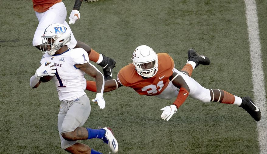 FILE - In this Oct. 19, 2019, file photo, Texas' DeMarvion Overshown (31) leaps to tackle Kansas running back Pooka Williams Jr. (1) during an NCAA college football game in Austin, Texas. Texas junior linebacker Overshown announced Thursday, July 2, 2020, he will sit out all team activities until the school starts making campus changes sought by dozens of football players and other Longhorns athletes. The demands made in early June include renaming several campus buildings currently named after former Texas officials with ties to the Confederacy and segregation, and a call to drop the school song “The Eyes of Texas.” (Nick Wagner/Austin American-Statesman via AP, File)