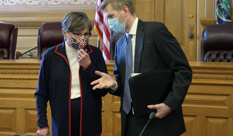 Kansas Gov. Laura Kelly, left, confers with Clay Britton, her chief attorney, before a meeting with legislative leaders about an executive order she issued to require people to wear masks in public, Thursday, July 2, 2020, at the Statehouse in Topeka, Kan. Kelly says she&#39;s worried that if the state doesn&#39;t reverse a recent surge in reported coronavirus cases, the state won&#39;t be able to reopen K-12 schools in August. (AP Photo/John Hanna)