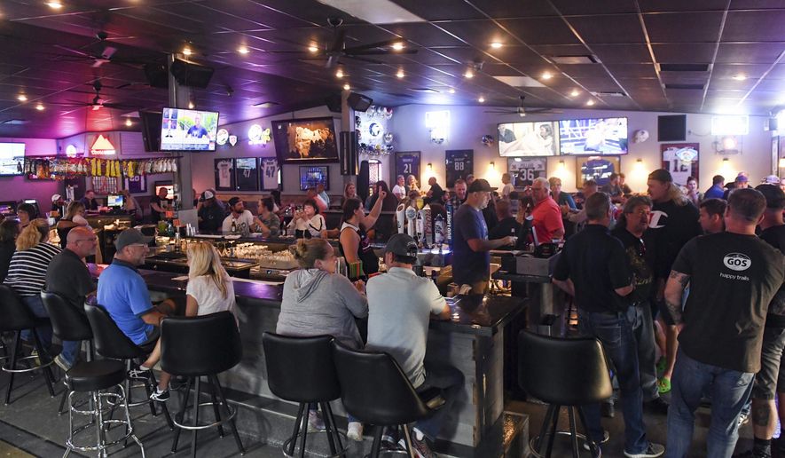 In this Thursday, June 18, 2020, file photo, patrons fill the Crow Bar in Sioux Falls, S.D. Authorities are closing bars and other drinking establishments in some parts of the U.S. to stem the surge of COVID-19 infections — a move backed by sound science about risk factors that go beyond wearing or not wearing masks. (Erin Bormett/The Argus Leader via AP, File)