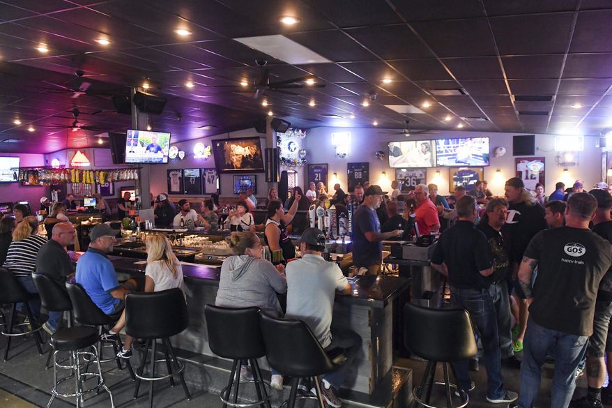In this Thursday, June 18, 2020, file photo, patrons fill the Crow Bar in Sioux Falls, S.D. Authorities are closing bars and other drinking establishments in some parts of the U.S. to stem the surge of COVID-19 infections — a move backed by sound science about risk factors that go beyond wearing or not wearing masks. (Erin Bormett/The Argus Leader via AP, File)