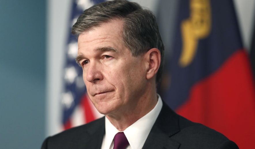 Gov. Roy Cooper listens to a question during a briefing at the Emergency Operations Center in Raleigh, N.C., Wednesday, July 1, 2020. (Ethan Hyman/The News & Observer via AP)