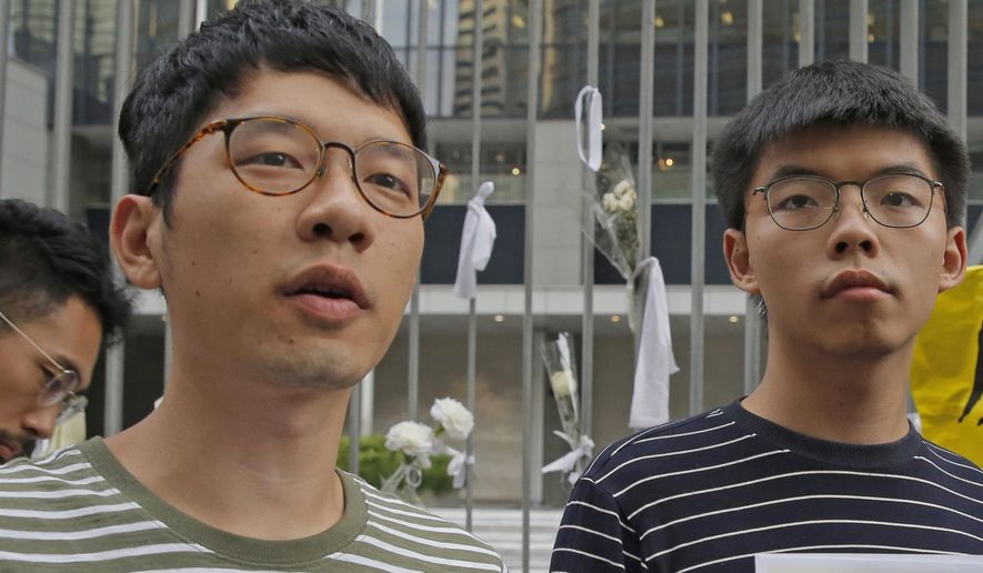 In this June 18, 2019, file photo, pro-democracy activists Nathan Law, left, and  Joshua Wong speak to the media outside a government office in Hong Kong. Prominent Hong Kong democracy activist Nathan Law has left the city for an undisclosed location, he revealed on his Facebook page shortly after testifying at a U.S. congressional hearing about the tough national security law China had imposed on the semi-autonomous territory.  In his post late Thursday, July 2, 2020, he said that he decided to take on the responsibility for advocating for Hong Kong internationally and had since left the city. (AP Photo/Kin Cheung, File)
