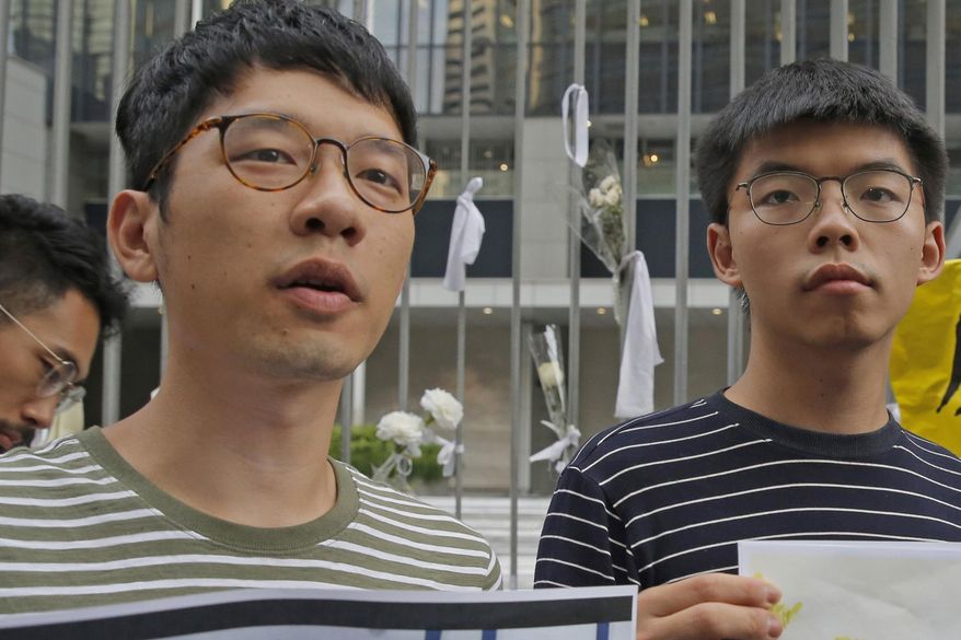 In this June 18, 2019, file photo, pro-democracy activists Nathan Law, left, and Joshua Wong speak to the media outside a government office in Hong Kong. Prominent Hong Kong democracy activist Nathan Law has left the city for an undisclosed location, he revealed on his Facebook page shortly after testifying at a U.S. congressional hearing about the tough national security law China had imposed on the semi-autonomous territory. In his post late Thursday, July 2, 2020, he said that he decided to take on the responsibility for advocating for Hong Kong internationally and had since left the city. (AP Photo/Kin Cheung, File)
