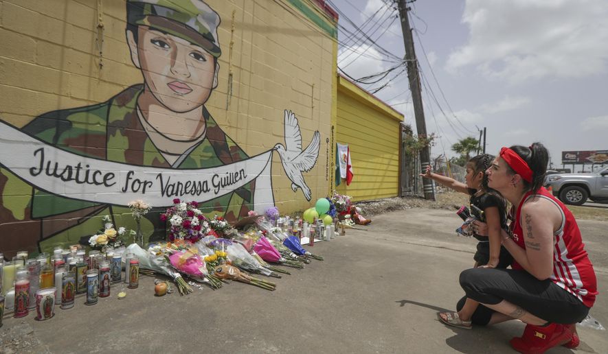 Dawn Gomez holds her 3-year-old granddaughter, Saryia Greer, who waves at Vanessa Guillen&#39;s mural painted by Alejandro &amp;quot;Donkeeboy&amp;quot; Roman Jr. on the side of Taqueria Del Sol, Thursday, July 2, 2020, in Houston. Army investigators believe Guillen, a Texas soldier missing since April, was killed by another soldier on the Texas base where they served, the attorney for the missing soldier&#39;s family said Thursday. (Steve Gonzales/Houston Chronicle via AP)