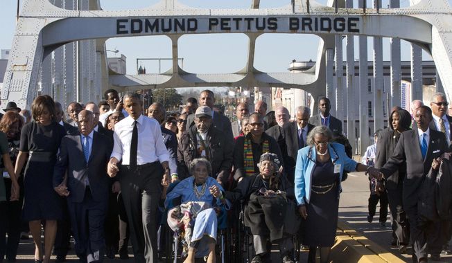 In this March 7, 2015, file photo, singing &amp;quot;We Shall Overcome,&amp;quot; President Barack Obama, third from left, walks holding hands with Amelia Boynton, who was beaten during &amp;quot;Bloody Sunday,&amp;quot; as they and the first family and others including Rep. John Lewis, D-Ga, left of Obama, walk across the Edmund Pettus Bridge in Selma, Ala., for the 50th anniversary of &amp;quot;Bloody Sunday,&amp;quot; a landmark event of the civil rights movement. Some residents in the landmark civil rights city of Selma, Ala., are among the critics of a bid to rename the historic bridge where voting rights marchers were beaten in 1965. (AP Photo/Jacquelyn Martin, File)