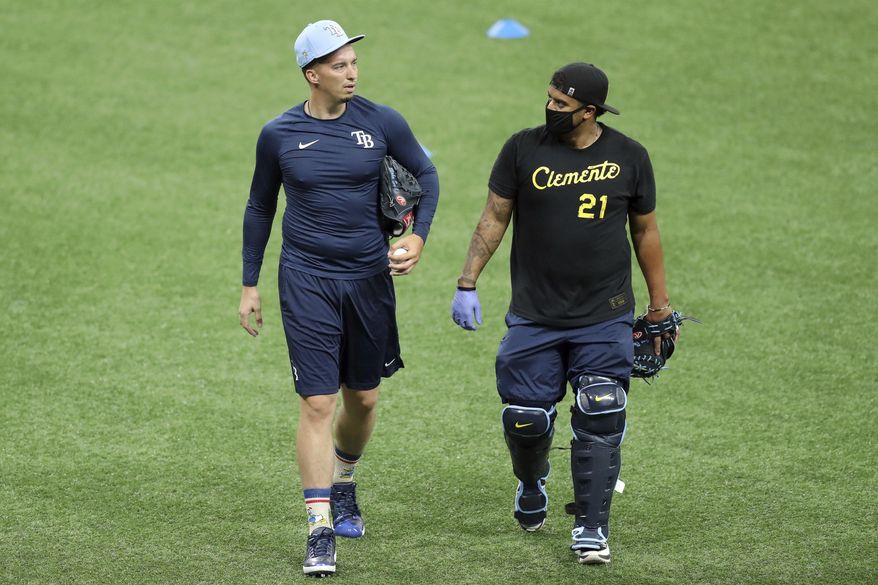 Tampa Bay Rays&#39; Blake Snell, left, talks with bullpen catcher Jean Ramirez during baseball practice Friday July 3, 2020, in St. Petersburg, Fla. Snell made headlines in May when he said he opposed the idea of players taking further pay reductions to start the season during a pandemic — that it was not worth the health risk. But he said Friday it wasn&#39;t difficult to start playing again after the players&#39; agreement with Major League Baseball included their full pro-rated salaries. (AP Photo/Mike Carlson)