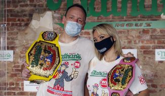 Competitive eaters Joey Chestnut, left, and Miki Sudo, right, pose for a photograph after winning their respective divisions with new world records after the Nathan&#39;s Famous July Fourth hot dog eating contest, Saturday, July 4, 2020, in the Brooklyn borough of New York. AP Photo/John Minchillo)