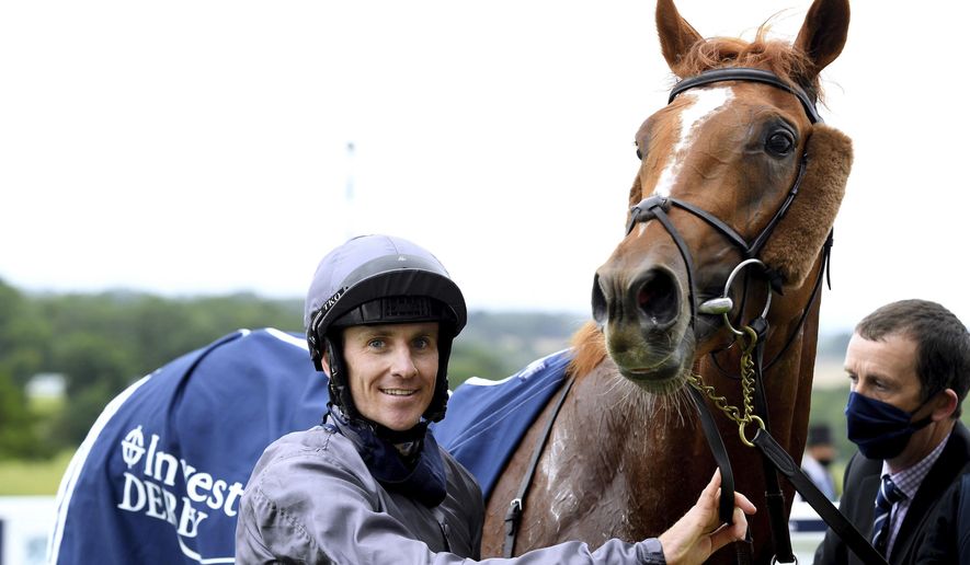 Jockey Emmet McNamara celebrates with Serpentine after winning the Investec Derby at Epsom Racecourse, in Epsom, England, Saturday, July 4, 2020. (Edward Whitaker/PA via AP)