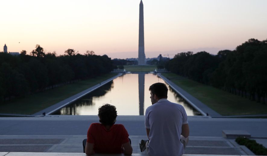 FILE - In this June 7, 2020, file photo, visitors watch sunrise from the Lincoln Memorial steps in Washington, the morning after massive protests over the death of George Floyd, who died after being restrained by Minneapolis police officers. (AP Photo/Patrick Semansky, File)