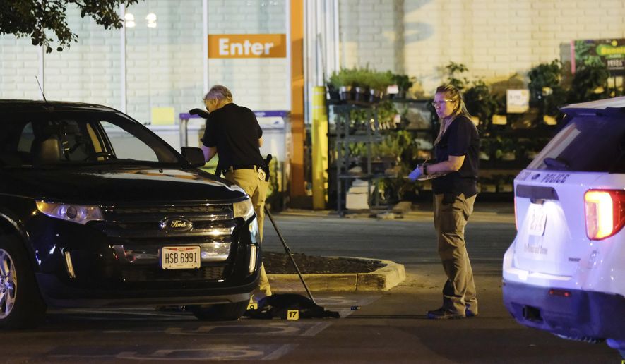 Police investigate the scene after a police officer was shot and killed in the parking lot of a Home Depot in Toledo, Ohio early Saturday, July 4, 2020. (Dave Zapotosky/The Blade via AP)