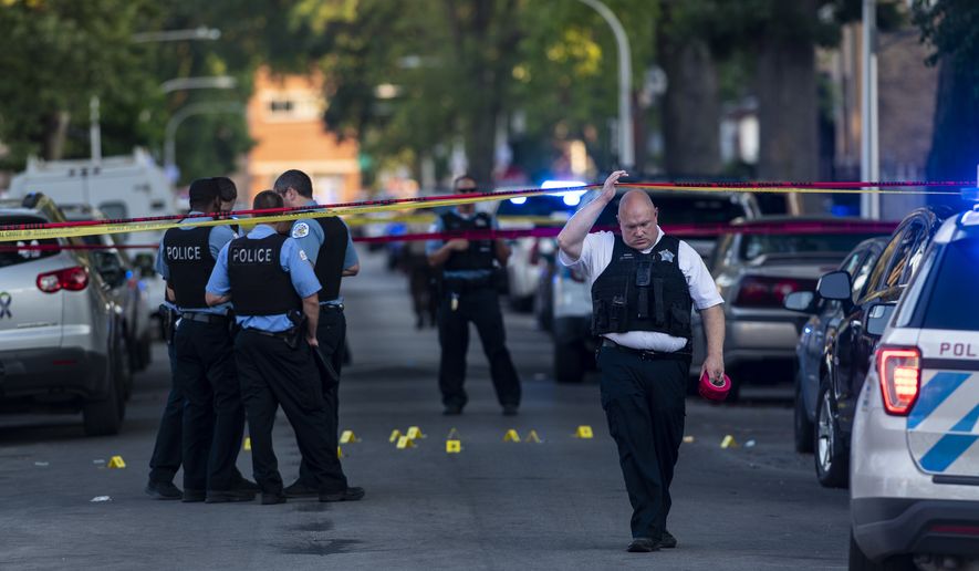 Chicago police officers investigate the scene of a deadly shooting in Chicago on Sunday, July 5, 2020, where a 7-year-old girl and a man were fatally shot during a Fourth of July party Saturday. At least a dozen people were killed in Chicago over the Fourth of July weekend, police said. Scores of people were shot and wounded. (Tyler LaRiviere/Chicago Sun-Times via AP)