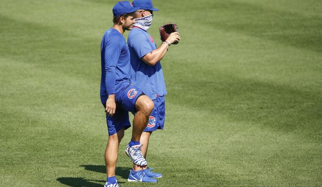 Chicago Cubs first baseman Anthony Rizzo, left, stands next to manager David Ross, right, during baseball practice at Wrigley Field, Sunday, July 5, 2020, in Chicago. (AP Photo/Kamil Krzaczynski)