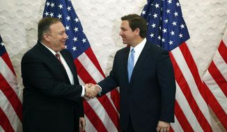FILE - In this Jan. 23, 2020, file photo, Secretary of State Mike Pompeo, left, and Florida Gov. Ron DeSantis pose for a photo before participating in a roundtable discussion with Venezuelan exiles, in Miami. While President Donald Trump deals with his high-profile political difficulties in his high-profile ways, his Cabinet heads are fanning out to battleground states in November&#39;s presidential vote, trying to assure essential support blocs on all that the Trump administration is doing for them. (AP Photo/Wilfredo Lee, File)