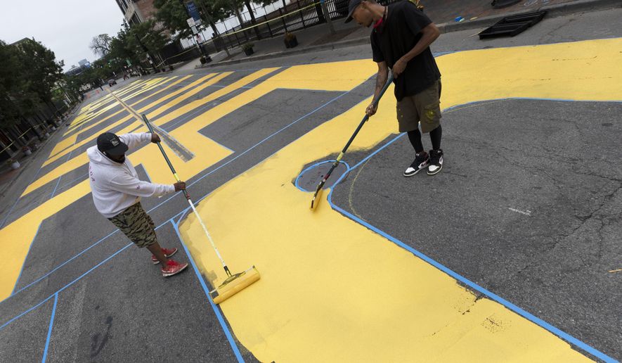 Lee Beard, left, and Mar, no last name given, paint the phrase Black Lives Matter on Washington Street, Sunday, July 5, 2020, in the Roxbury neighborhood of Boston. (AP Photo/Michael Dwyer)