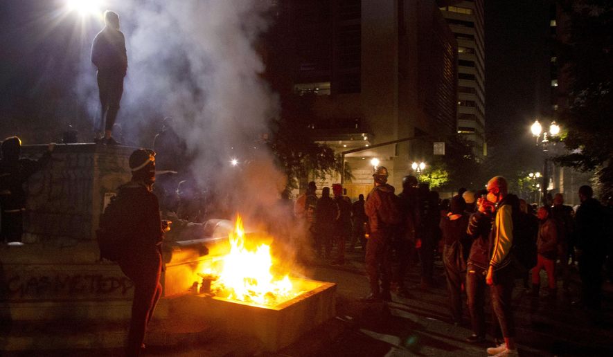 Twice on July Fourth, police declared a riot in downtown Portland, Ore., July 4, 2020. Portland police say more than 12 people were arrested early Sunday after throwing fireworks and mortars as they clashed with police during the latest rally decrying police brutality. (Beth Nakamura/The Oregonian via AP)