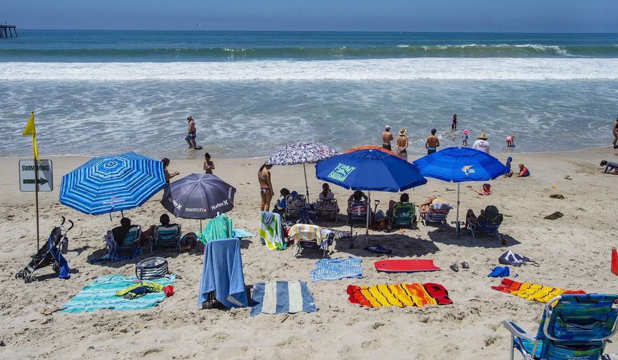 With most of Southern California&#39;s coastline is shut down for the Fourth of July holiday due to a spike in coronavirus cases, the beach in San Clemente, Calif., remains open as crowds, socially distanced, fill the sand Saturday, July 4, 2020. (Mark Rightmire/The Orange County Register via AP)