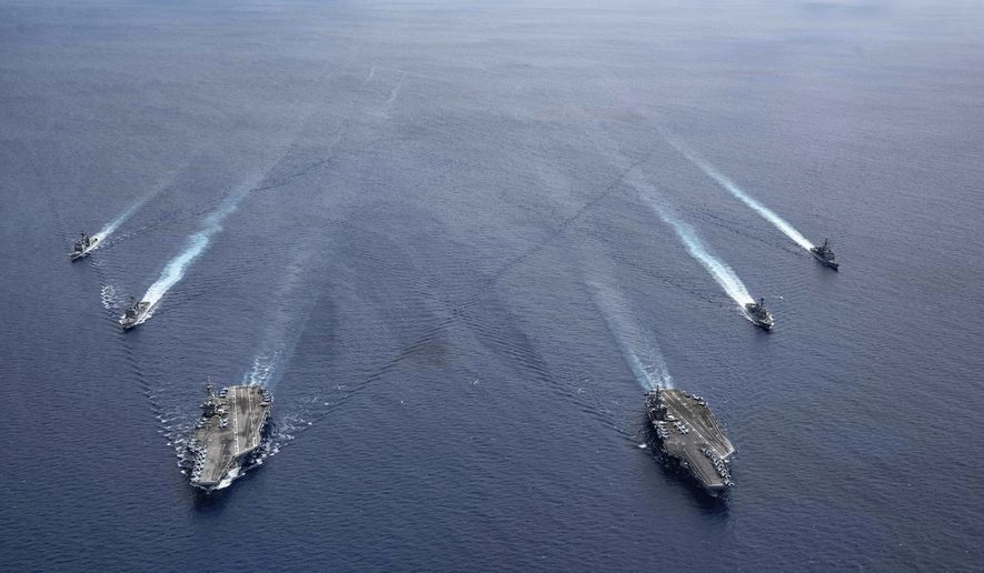In this photo provided by U.S. Navy, the USS Ronald Reagan (CVN 76) and USS Nimitz (CVN 68) Carrier Strike Groups steam in formation, in the South China Sea, Monday, July 6, 2020. (Mass Communication Specialist 3rd Class Jason Tarleton/U.S. Navy via AP)  **FILE**
