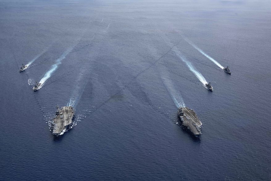 In this photo provided by U.S. Navy, the USS Ronald Reagan (CVN 76) and USS Nimitz (CVN 68) Carrier Strike Groups steam in formation, in the South China Sea, Monday, July 6, 2020. (Mass Communication Specialist 3rd Class Jason Tarleton/U.S. Navy via AP)  **FILE**