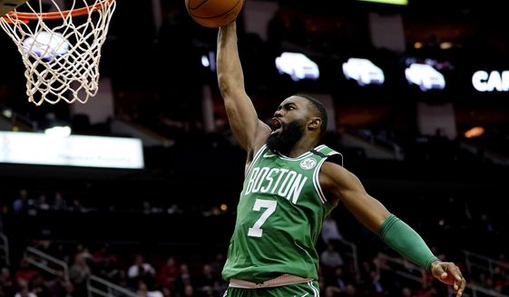 FILE - In this Feb. 11, 2020, file photo, Boston Celtics&#39; Jaylen Brown goes up to dunk against the Houston Rockets during the second half of an NBA basketball game in Houston. Brown is encouraged by the steps the NBA is taking to connect with its players’ desire to support social justice causes. He also says he wants to see the league go further with some of those plans as it prepares to restart the season later in Florida. (AP Photo/David J. Phillip, File)