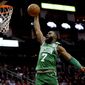 FILE - In this Feb. 11, 2020, file photo, Boston Celtics&#39; Jaylen Brown goes up to dunk against the Houston Rockets during the second half of an NBA basketball game in Houston. Brown is encouraged by the steps the NBA is taking to connect with its players’ desire to support social justice causes. He also says he wants to see the league go further with some of those plans as it prepares to restart the season later in Florida. (AP Photo/David J. Phillip, File)