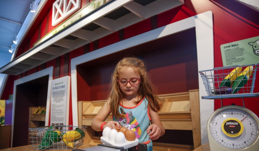 Veronica Adamson, 4, plays in the marketplace exhibit during the opening of Washington Pavilion&#x27;s &amp;quot;Grow It!,&amp;quot; on Thursday, June 25, 2020 in Sioux Falls, S.D. A bright, red barn and puffy, white clouds welcomes people into the Washington Pavilion’s newest exhibition, “Grow It!” The addition to the Kirby Science Discovery Center was revealed June 25 and features 3,000 square feet of interactive agriculture experiences.(Abigail Dollins/The Argus Leader via AP)