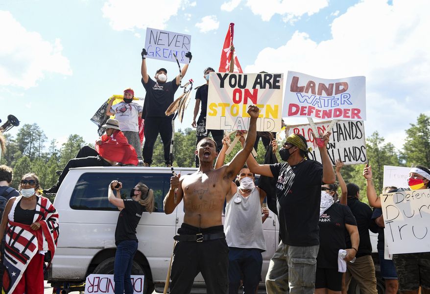 Protesters form a blockade of vans and bodies on the highway leading to Mount Rushmore on Friday, July 3, 2020, in Keystone, S.D. President Donald Trump spoke at Mount Rushmore National Memorial. (Erin Bormett/The Argus Leader via AP)