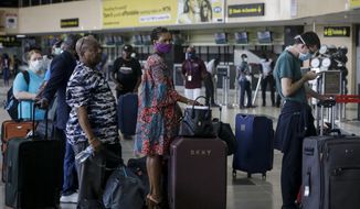 In this Tuesday, April 7, 2020, file photo, U.S. citizens queue to check in and be repatriated aboard an evacuation flight arranged by the U.S. embassy and chartered with Delta Air Lines, at the Murtala Mohammed International Airport in Lagos, Nigeria. African nations face a difficult choice as infections are rapidly rising: Welcome the international flights that originally brought COVID-19 to the ill-prepared continent, or further hurt their economies. (AP Photo/Sunday Alamba, File)