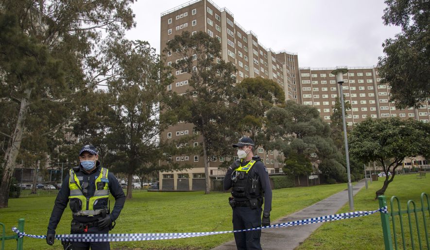 Police guard access to housing commission apartments under lockdown in Melbourne, Australia, on Monday, July 6, 2020. The hard-hit Australian state of Victoria recorded two deaths and its highest-ever daily increase in coronavirus cases on Monday as authorities prepare to close its border with New South Wales. (AP Photo/Andy Brownbill)