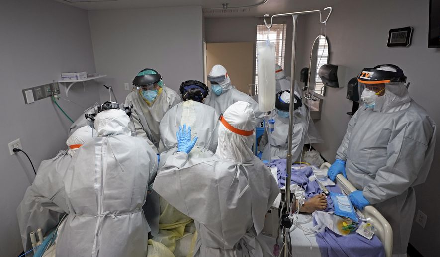 Dr. Joseph Varon, right, leads a team as they try to save the life of a patient unsuccessfully inside the Coronavirus Unit at United Memorial Medical Center, Monday, July 6, 2020, in Houston. Hospitalizations due to COVID-19 in the second-largest state in the U.S. have more than doubled in the last two weeks. (AP Photo/David J. Phillip)