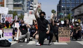 In this May 31, 2020, file photo, demonstrators kneel in a moment of silence outside the Long Beach Police Department in Long Beach during a protest over the death of George Floyd. Proposed federal legislation that would radically transform the nation&#x27;s criminal justice system through such changes as eliminating agencies like the Drug Enforcement Administration and the use of federal surveillance technology is set to be unveiled Tuesday, July 7, by the Movement for Black Lives. (AP Photo/Ashley Landis, File)
