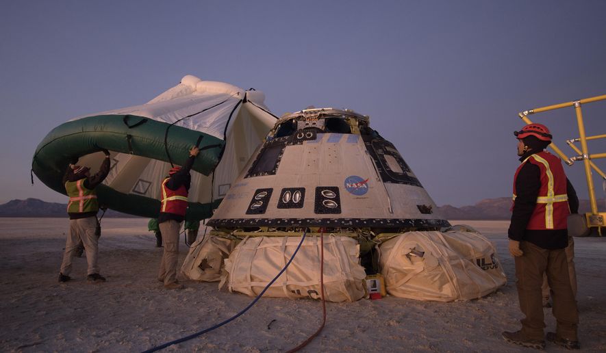 FILE - In this Sunday, Dec. 22, 2019 photo made available by NASA, Boeing, NASA, and U.S. Army personnel work around the Boeing Starliner spacecraft shortly after it landed in White Sands, N.M. On Tuesday, July 7, 2020, NASA officials said they have identified 80 corrective actions for safety, mostly involving software, that must be implemented before the Starliner capsule launches again. The previous count was 61.  (Bill Ingalls/NASA via AP)