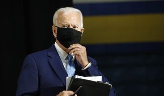 Democratic presidential candidate, former Vice President Joe Biden puts on a face mask to protect against the spread of the new coronavirus as he departs after speaking at Alexis Dupont High School in Wilmington, Del., Tuesday, June 30, 2020. (AP Photo/Patrick Semansky) ** FILE **