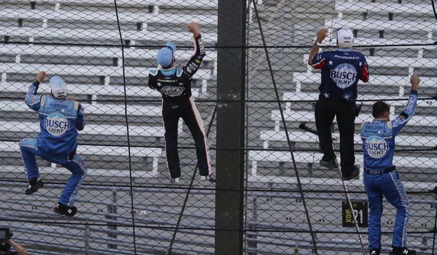 Kevin Harvick, second from left, and some members of the team's crew climb the fence after Harvick won the NASCAR Cup Series auto race at Indianapolis Motor Speedway in Indianapolis, Sunday, July 5, 2020. (AP Photo/Darron Cummings)